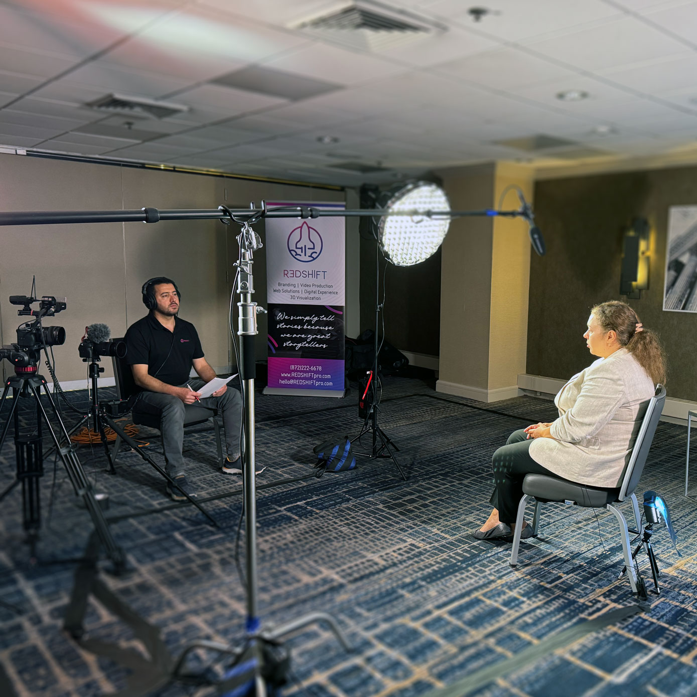 A man films an interview with woman